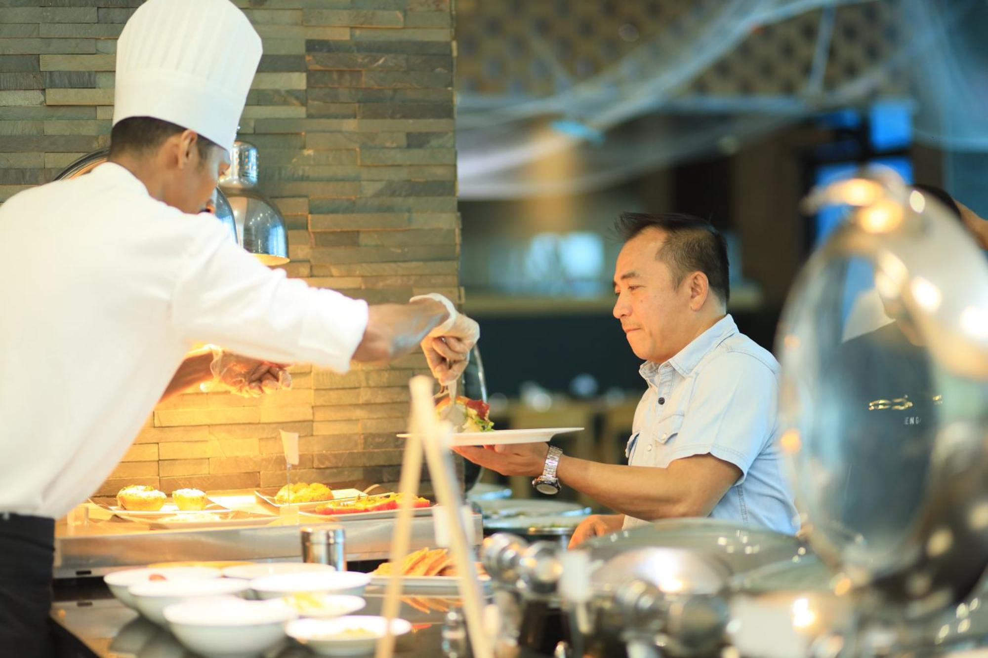 Ramee Grand Hotel And Spa Манама Экстерьер фото A chef serving food at a buffet